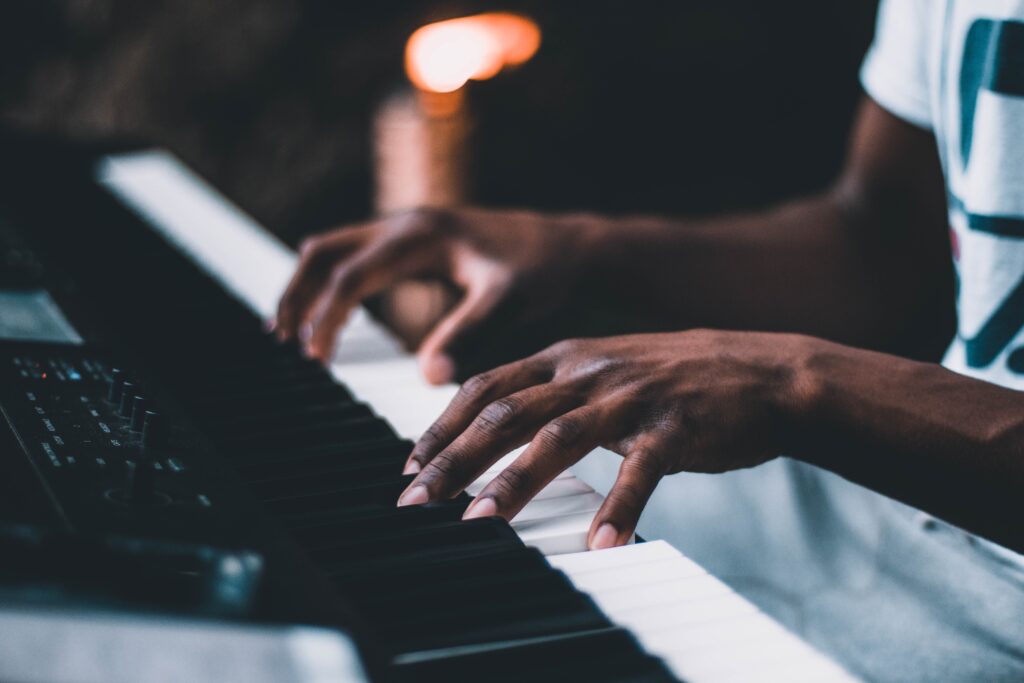 A man's hands playing a digital piano.